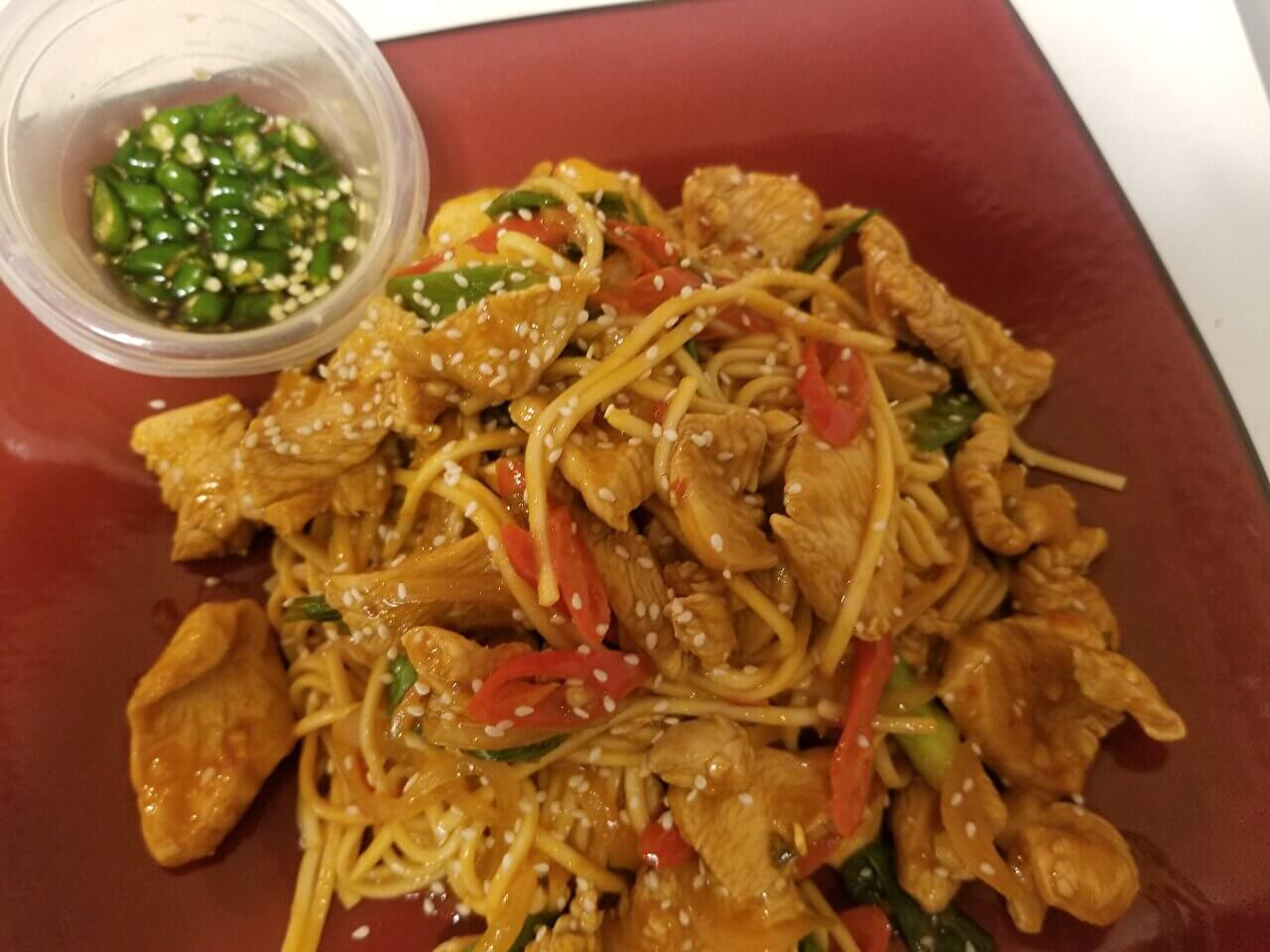 Spicy chicken noodles with prik nam pla on the side